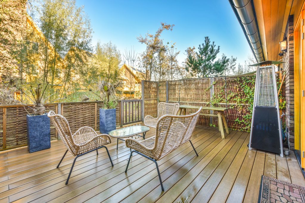 Large house backyard light-colored wooden deck outside of home in the fall