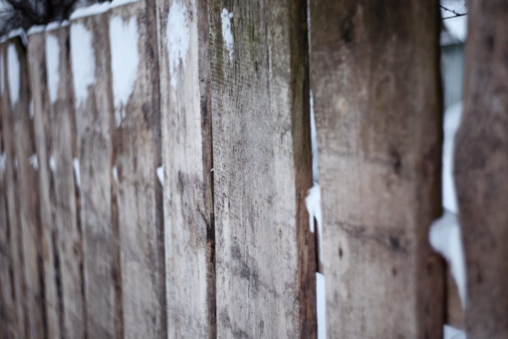 snowfall causing necessary fence repair to wooden fence 